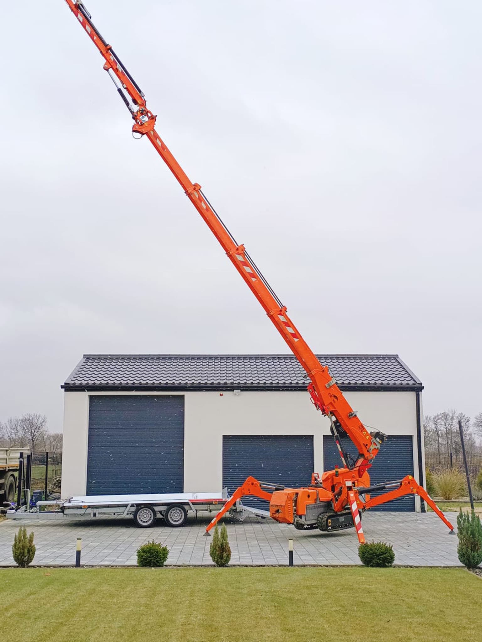 Mini żuraw JEKKO SPX 424 w trakcie pracy przy montażu szklanej fasady